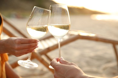 Photo of Romantic couple drinking wine together on beach, closeup