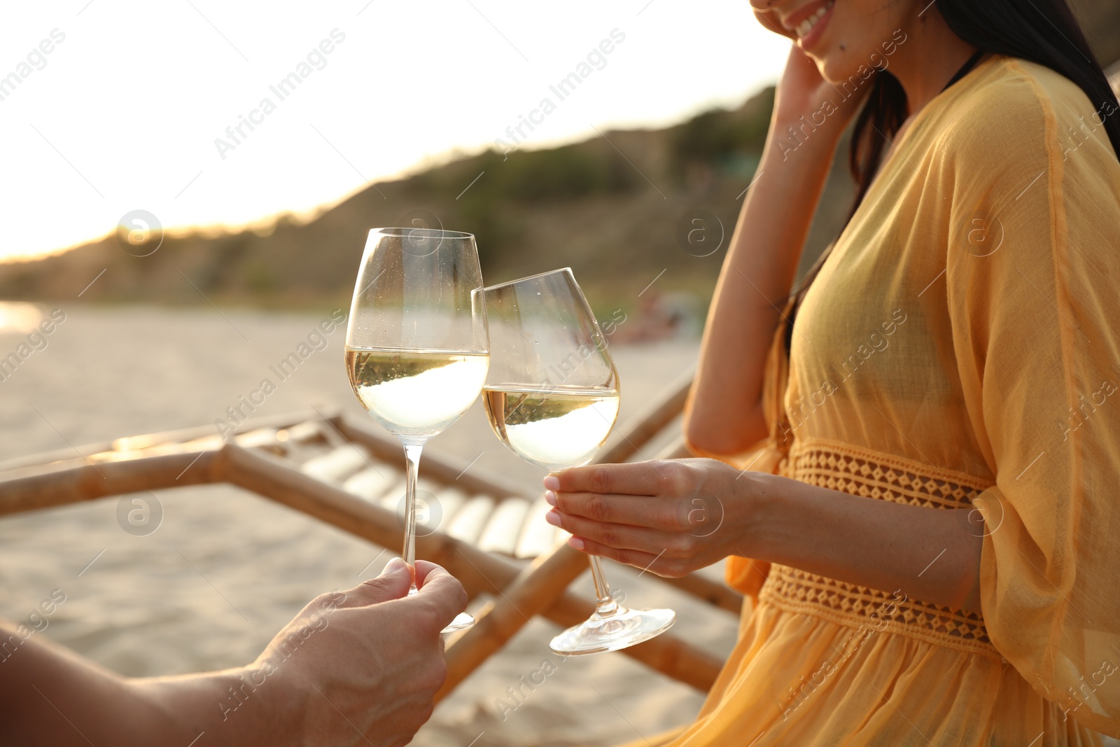 Photo of Romantic couple drinking wine together on beach, closeup