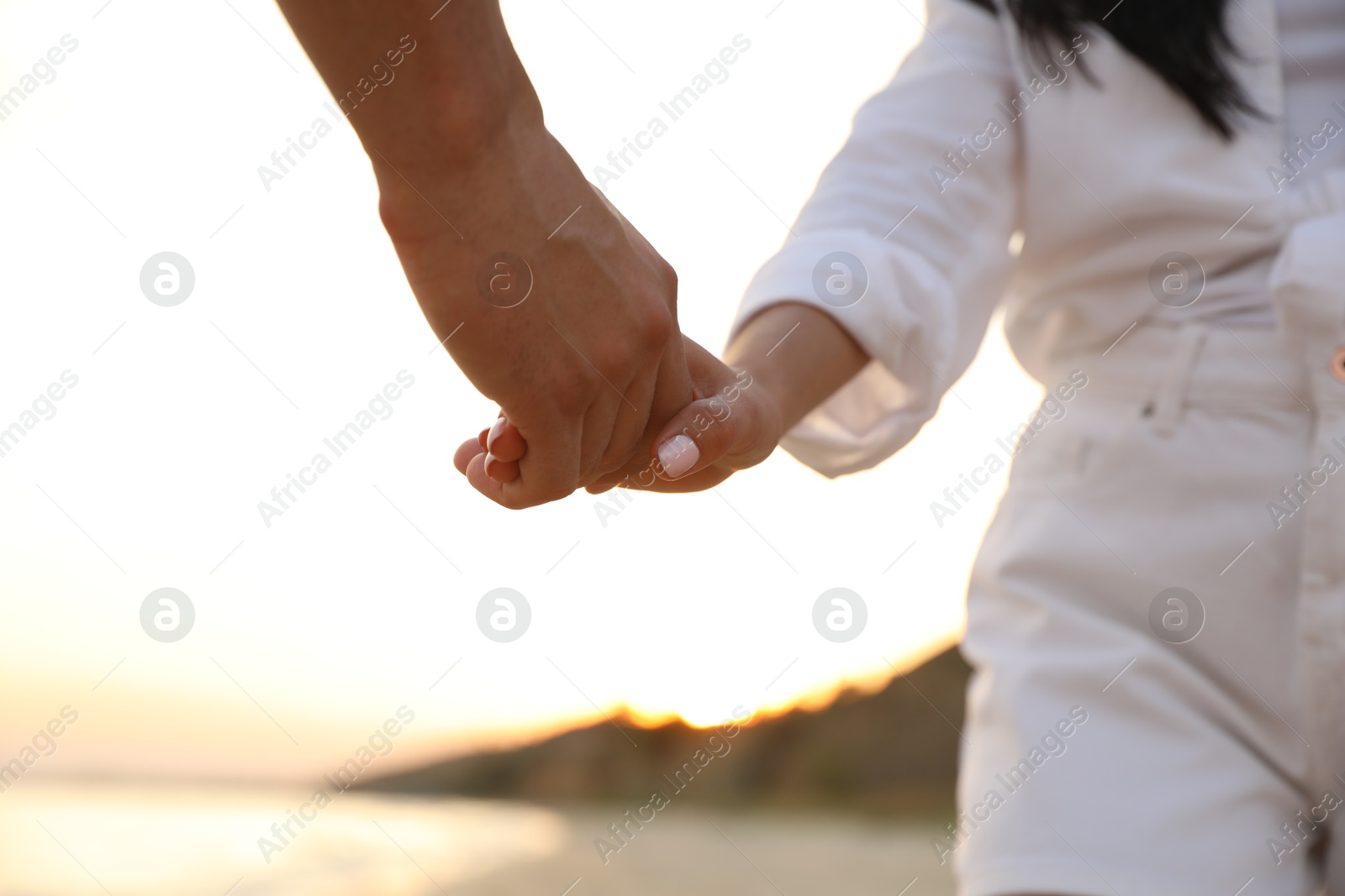 Photo of Lovely couple holding hands on beach, closeup