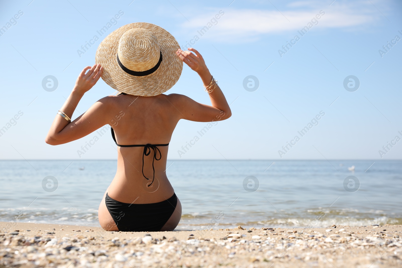 Photo of Young woman with beautiful body on sandy beach. Space for text