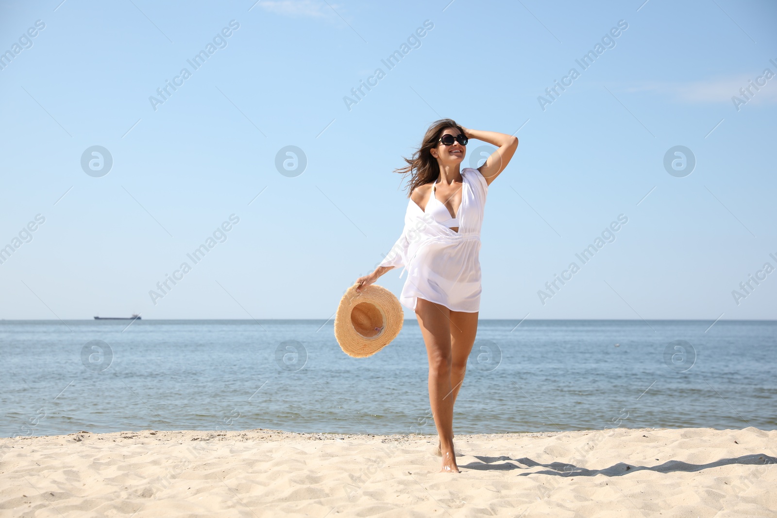 Photo of Young woman with beautiful body on sandy beach. Space for text