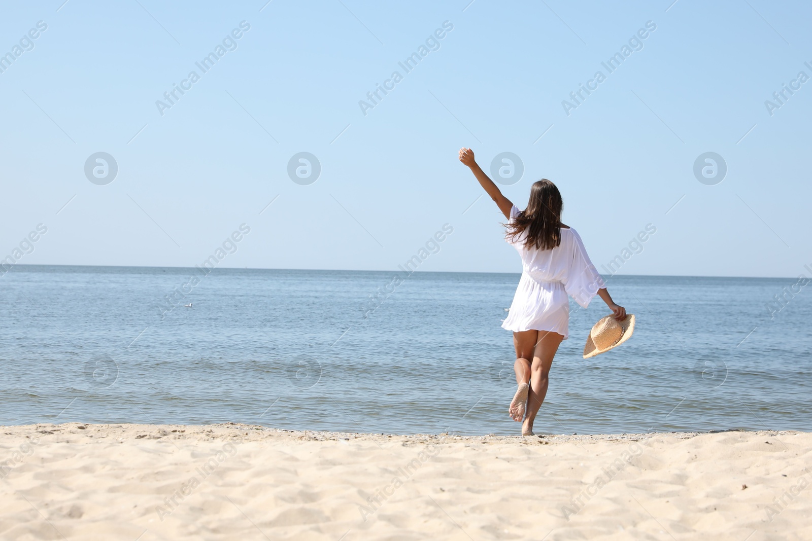 Photo of Young woman with beautiful body on sandy beach. Space for text