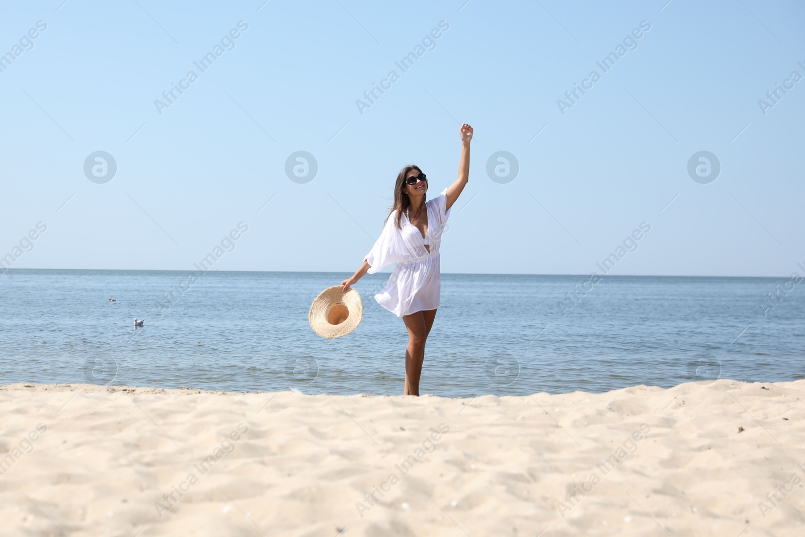 Photo of Young woman with beautiful body on sandy beach. Space for text