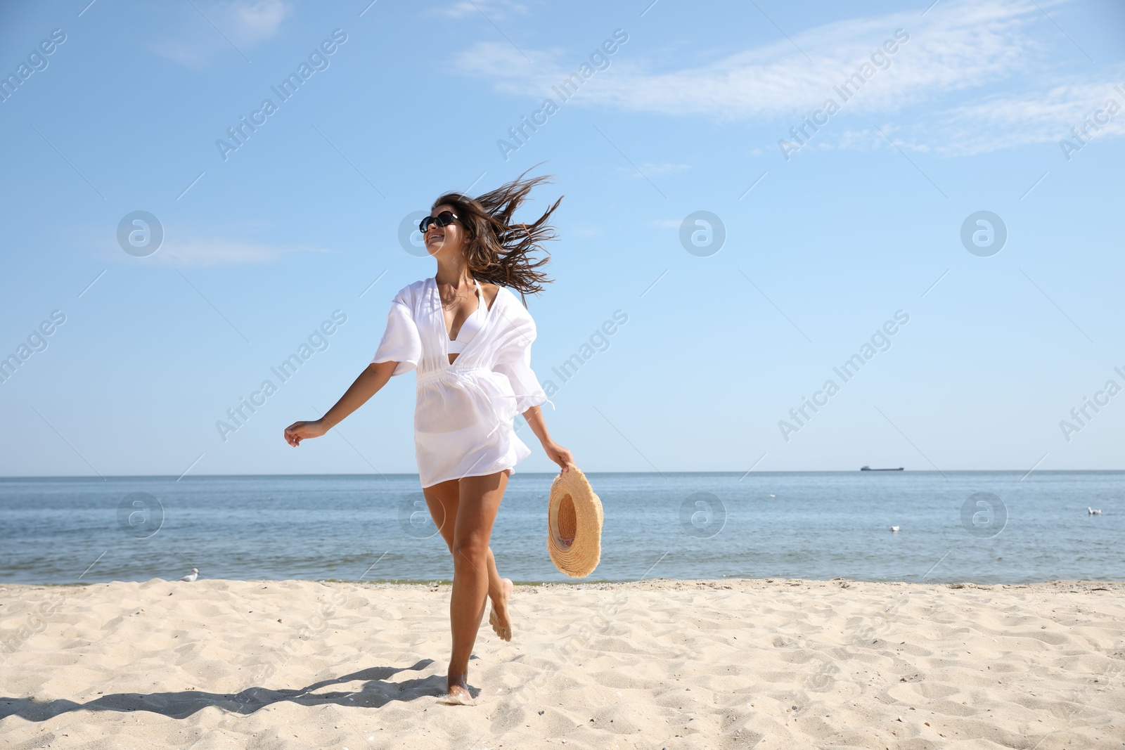 Photo of Young woman with beautiful body on sandy beach. Space for text