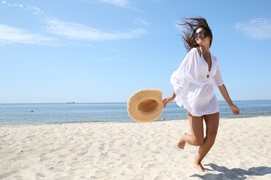 Photo of Young woman with beautiful body on sandy beach. Space for text