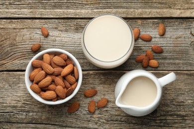 Photo of Fresh almond milk and nuts on wooden table, top view