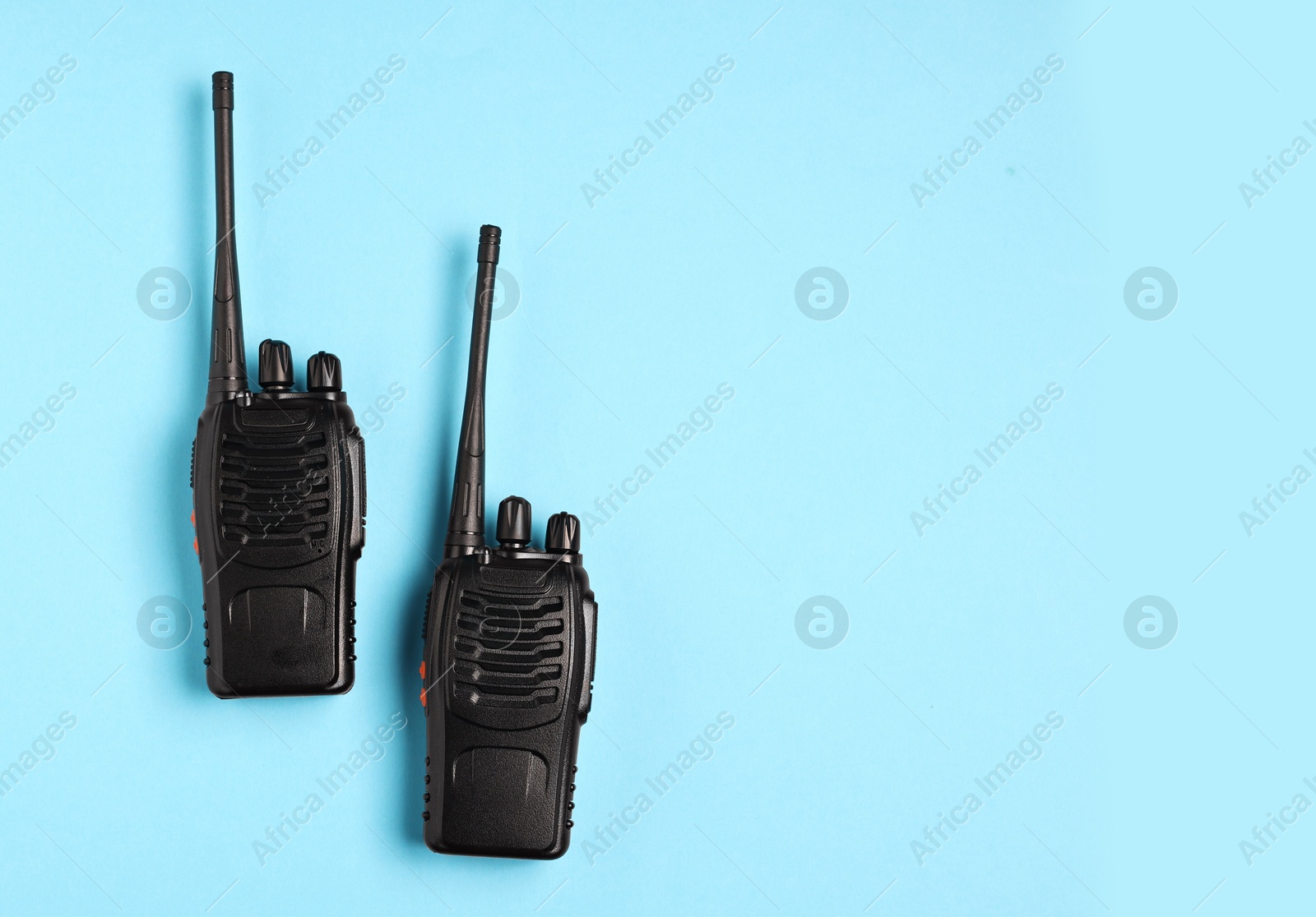 Photo of Walkie talkies on light blue background, top view. Space for text