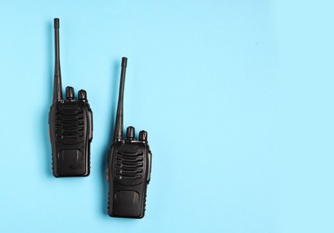 Photo of Walkie talkies on light blue background, top view. Space for text