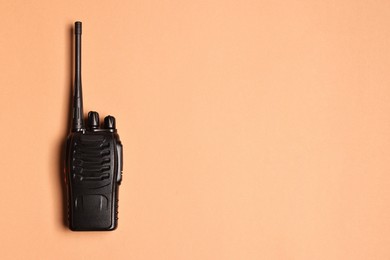 Photo of One walkie talkie on beige background, top view. Space for text