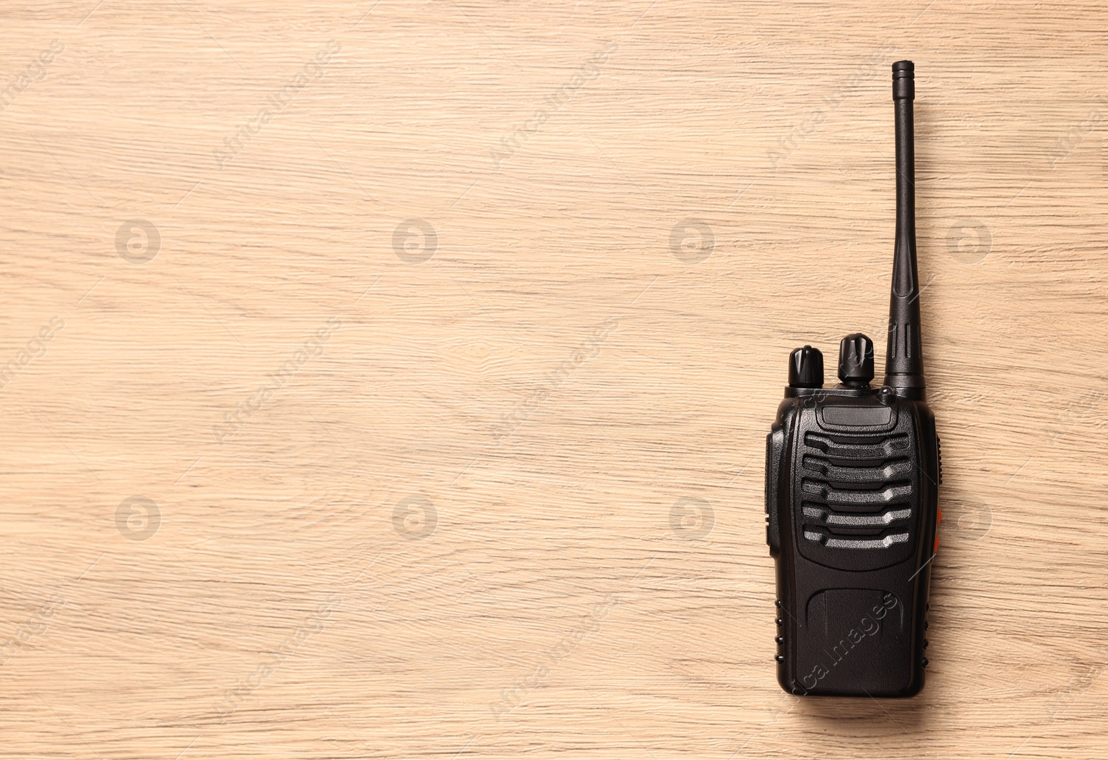 Photo of One walkie talkie on wooden table, top view. Space for text