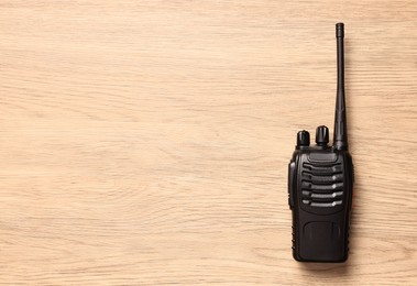 Photo of One walkie talkie on wooden table, top view. Space for text