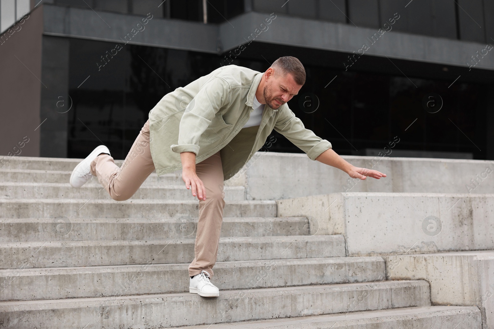 Photo of Man falling on stairs outdoors. Dangerous accident