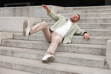 Photo of Man falling on stairs outdoors. Dangerous accident