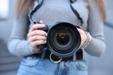 Photo of Professional photographer with digital camera outdoors, closeup