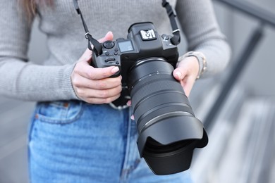 Photo of Professional photographer with digital camera outdoors, closeup