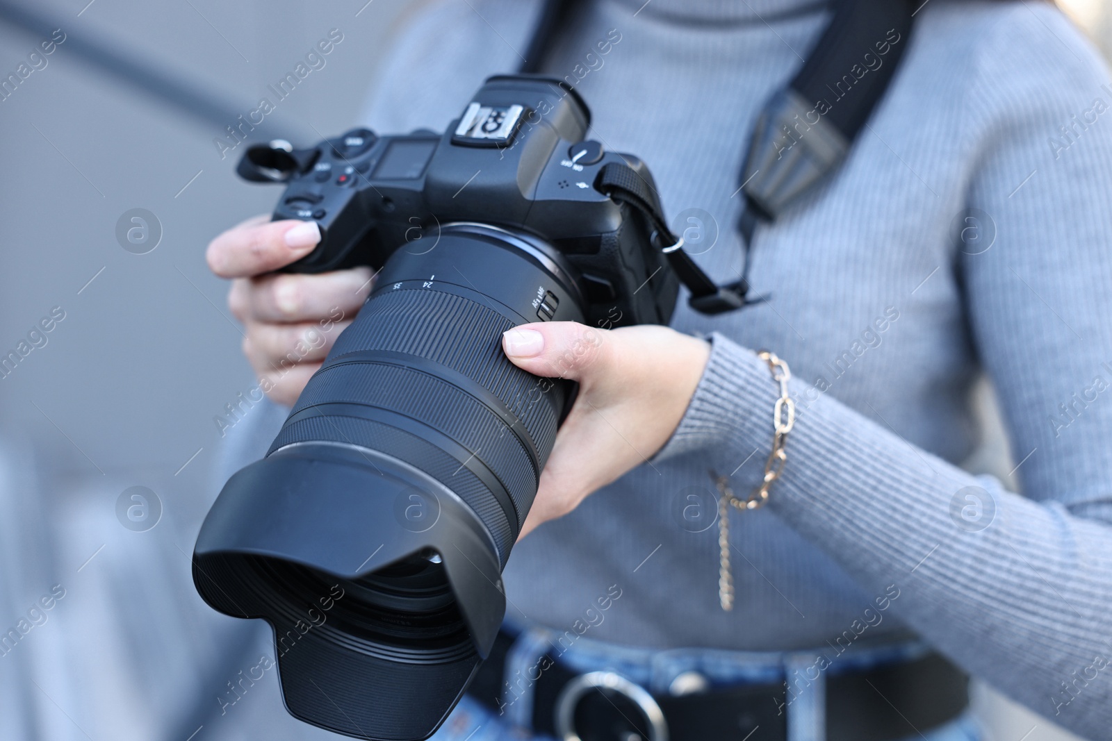 Photo of Professional photographer with digital camera outdoors, closeup