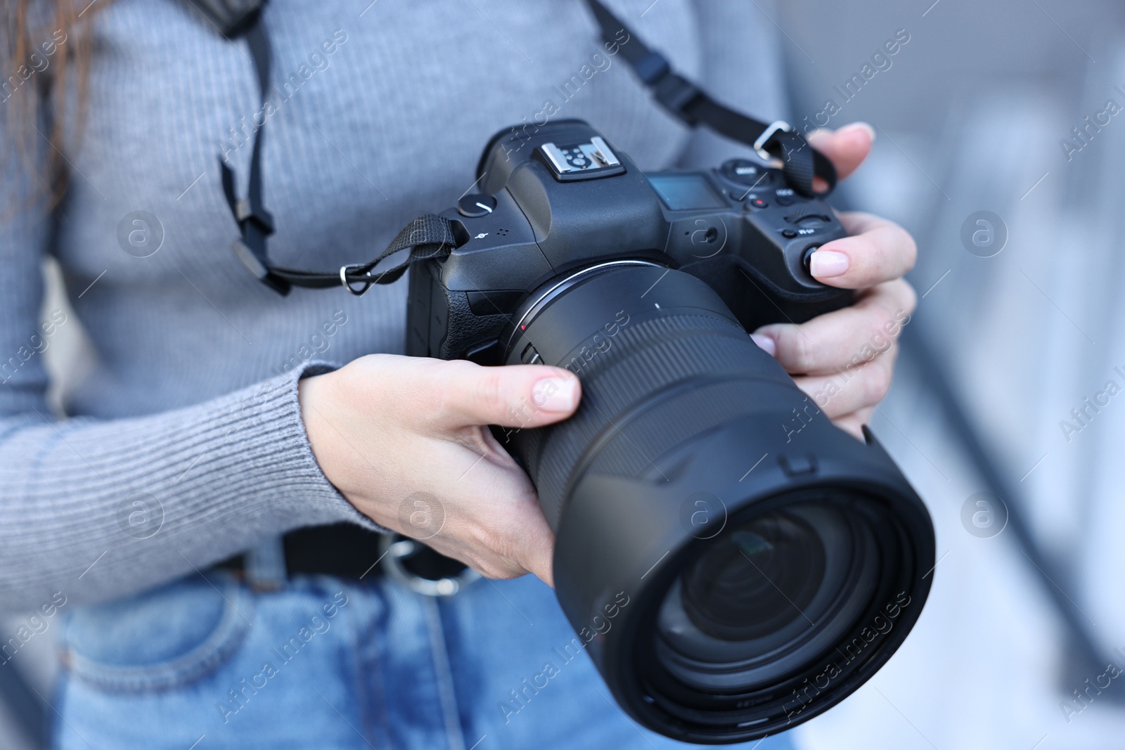 Photo of Professional photographer with digital camera outdoors, closeup