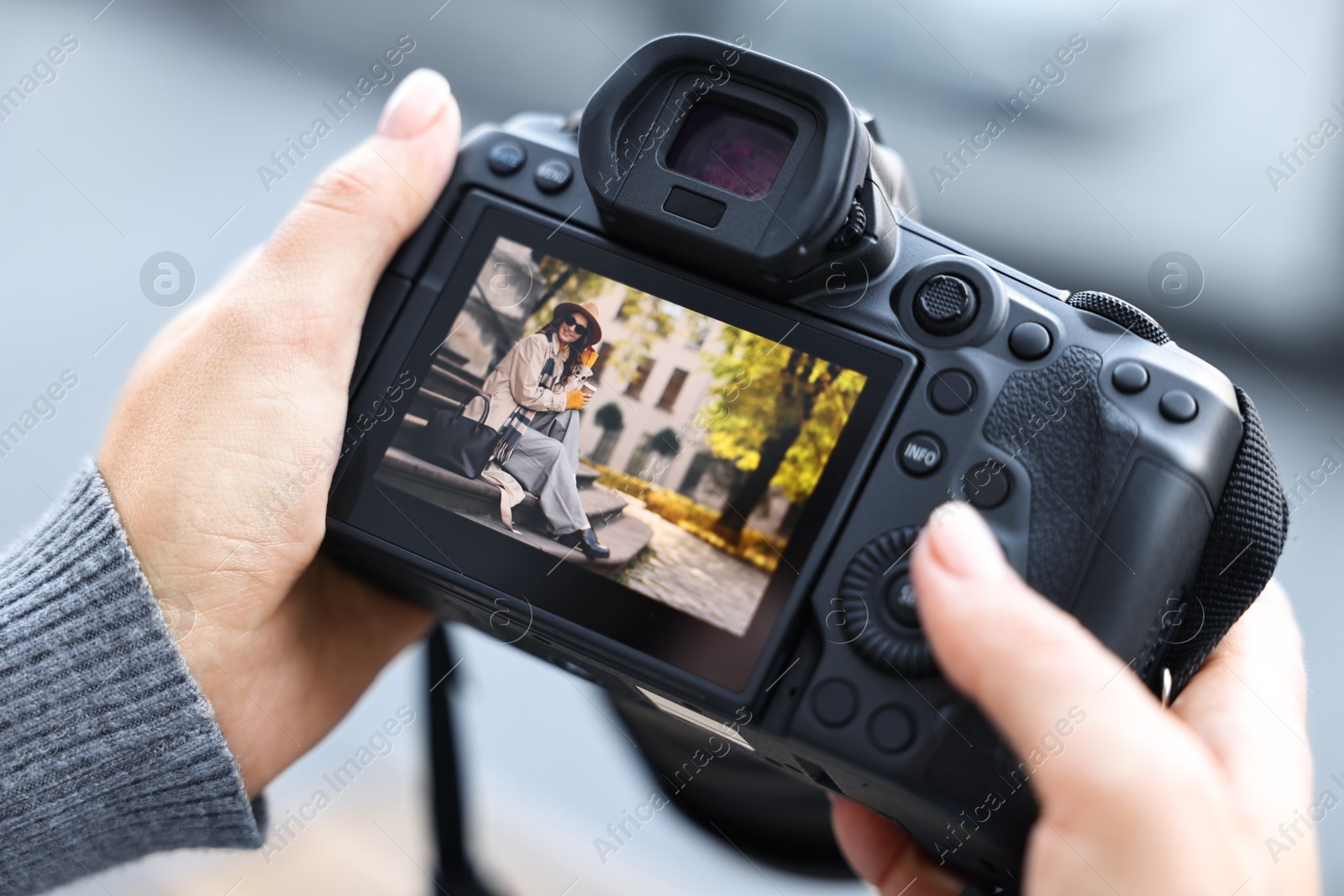 Photo of Professional photographer with digital camera outdoors, closeup