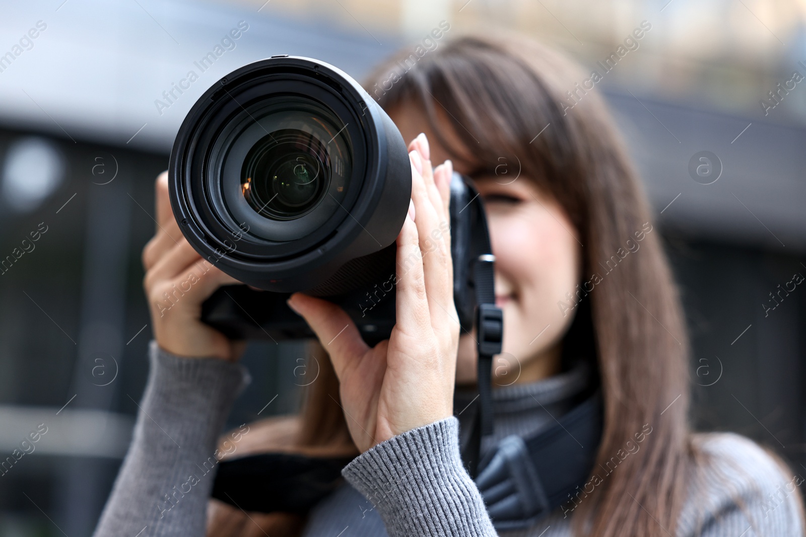 Photo of Professional photographer taking picture with camera outdoors, selective focus