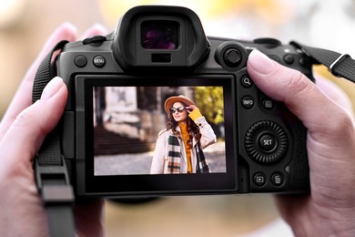 Photo of Professional photographer with digital camera outdoors, closeup