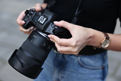 Photo of Professional photographer with digital camera outdoors, closeup