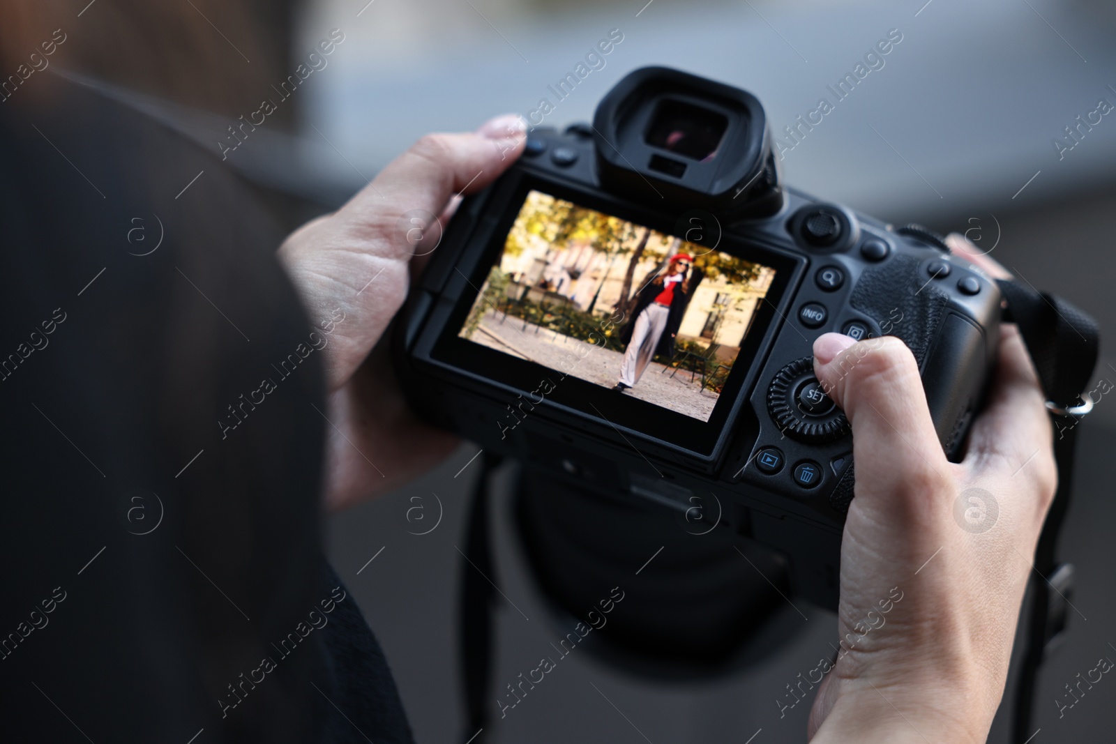 Photo of Professional photographer with digital camera outdoors, closeup