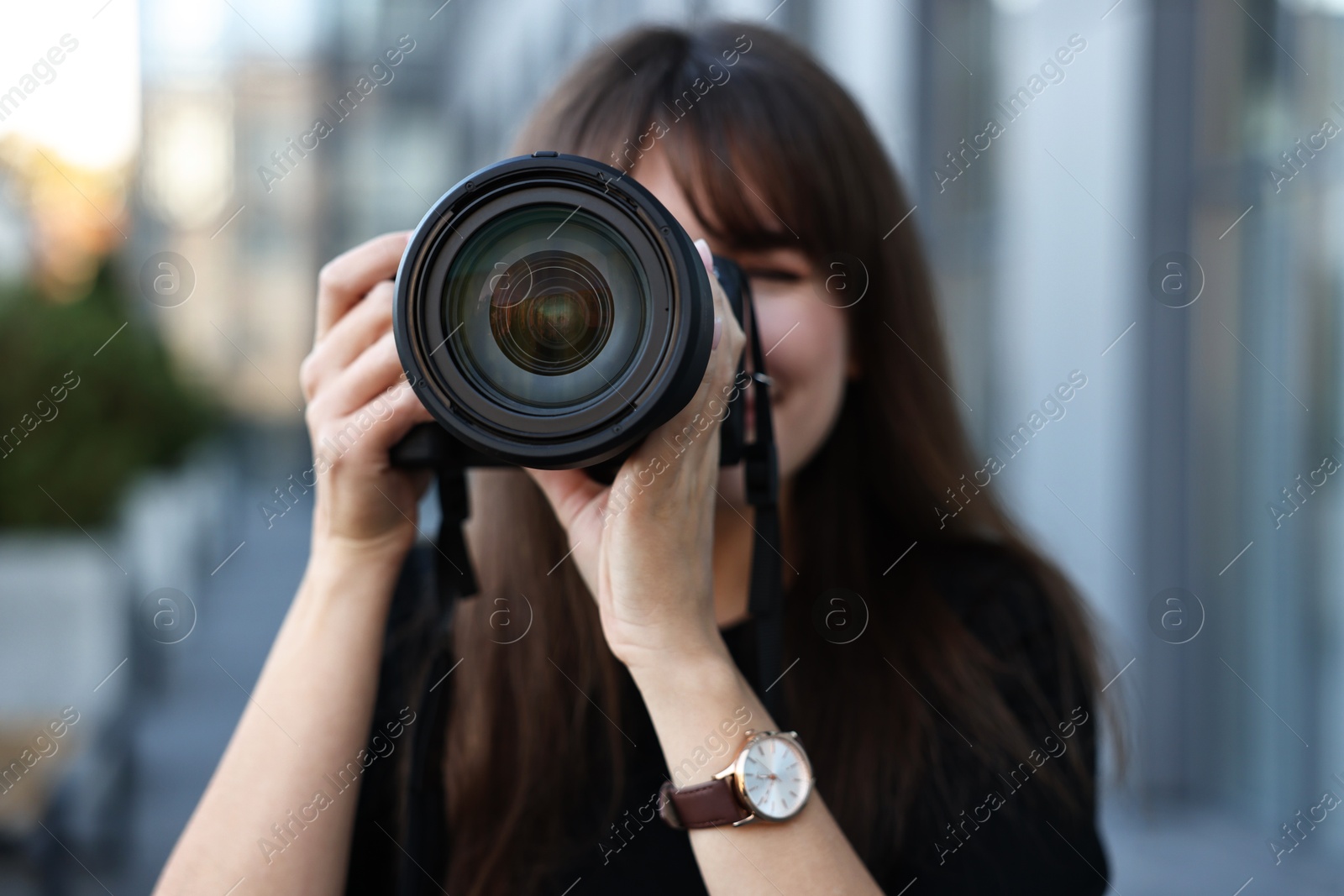 Photo of Professional photographer taking picture with camera outdoors, selective focus