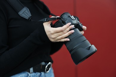 Photo of Professional photographer with digital camera outdoors, closeup