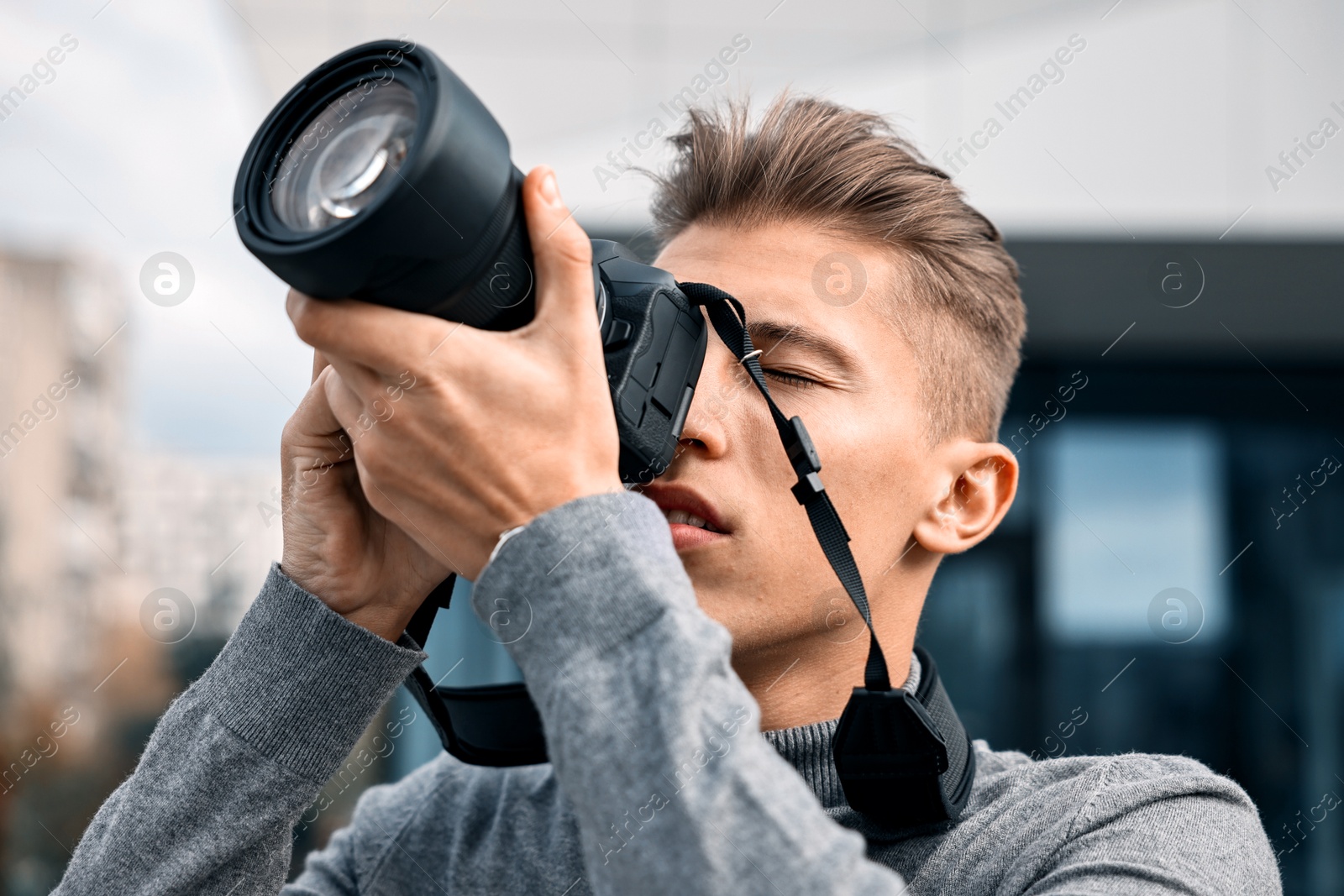 Photo of Professional photographer taking picture with camera outdoors