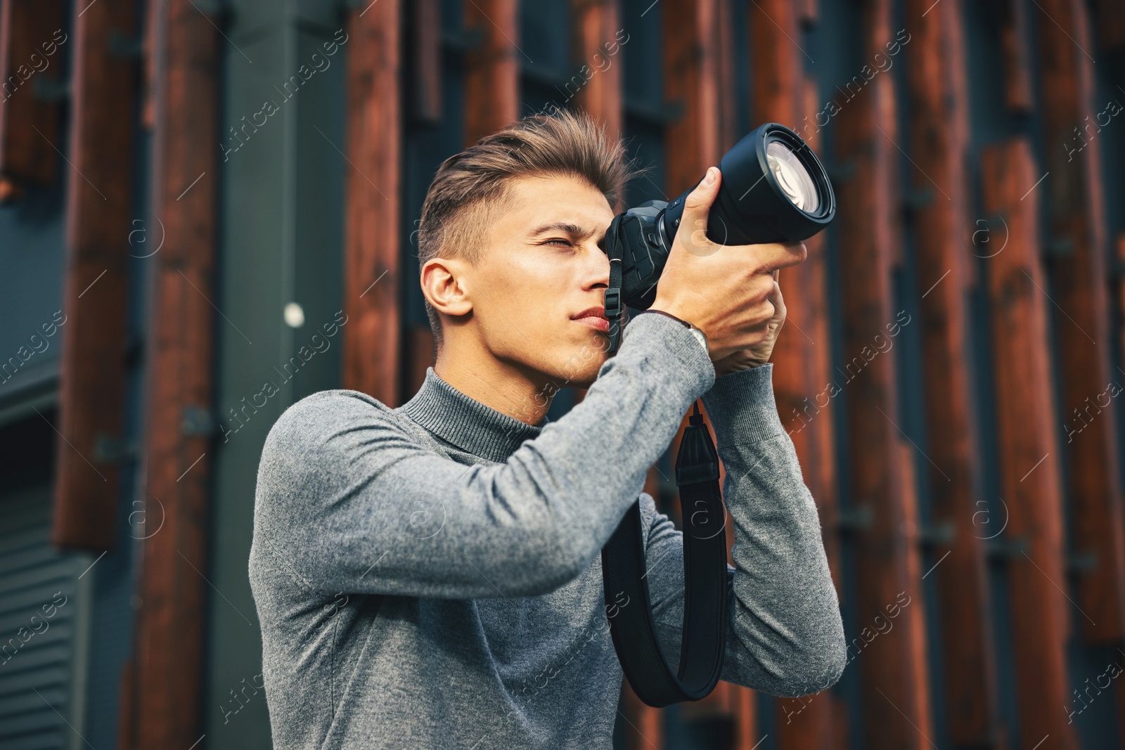 Photo of Professional photographer taking picture with camera outdoors