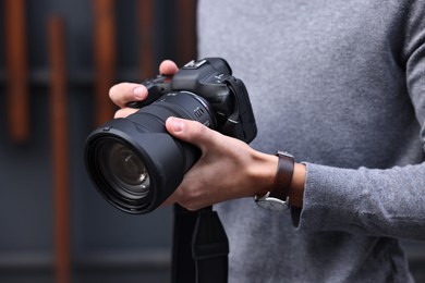 Photo of Professional photographer with modern camera outdoors, closeup