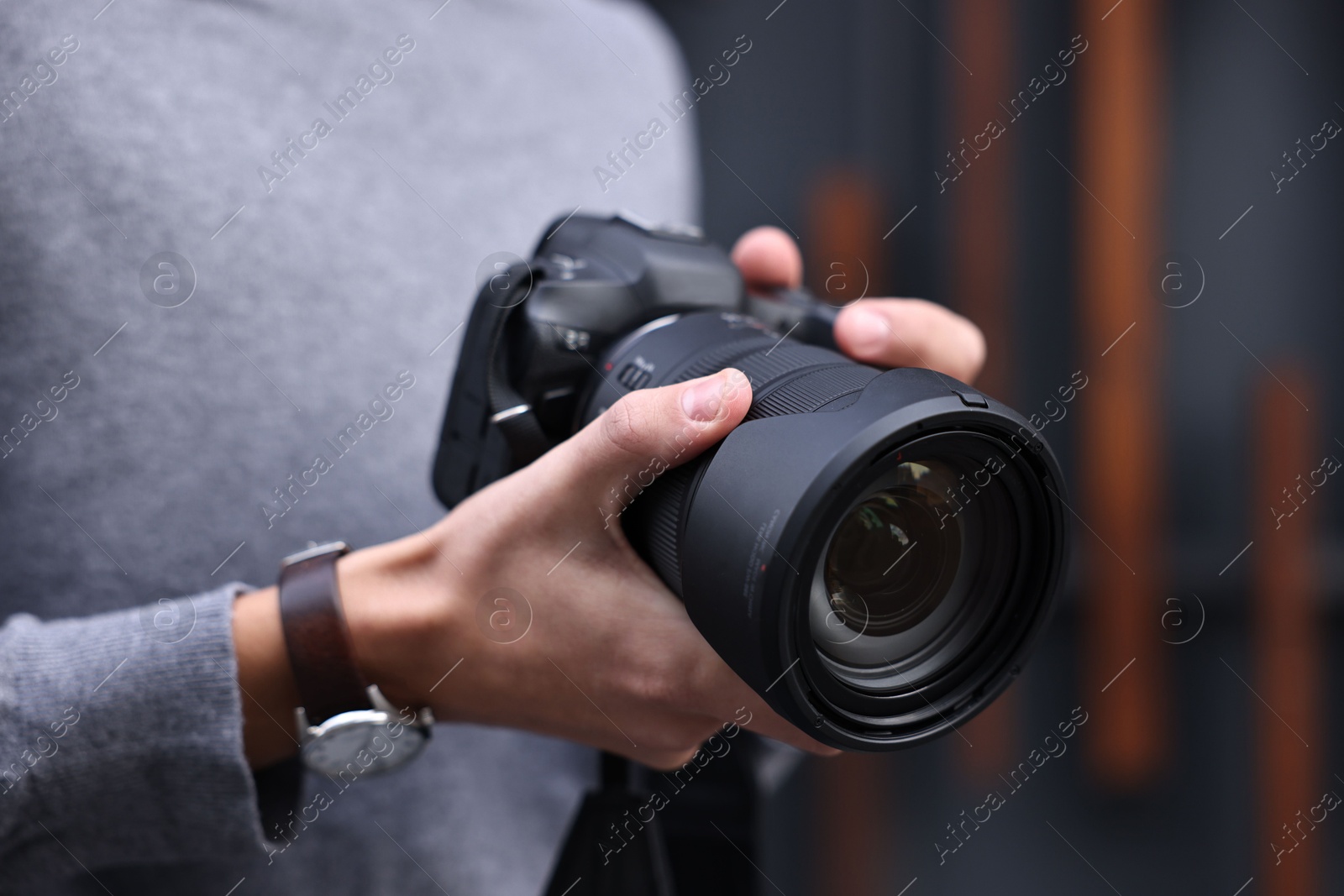 Photo of Professional photographer with modern camera outdoors, closeup