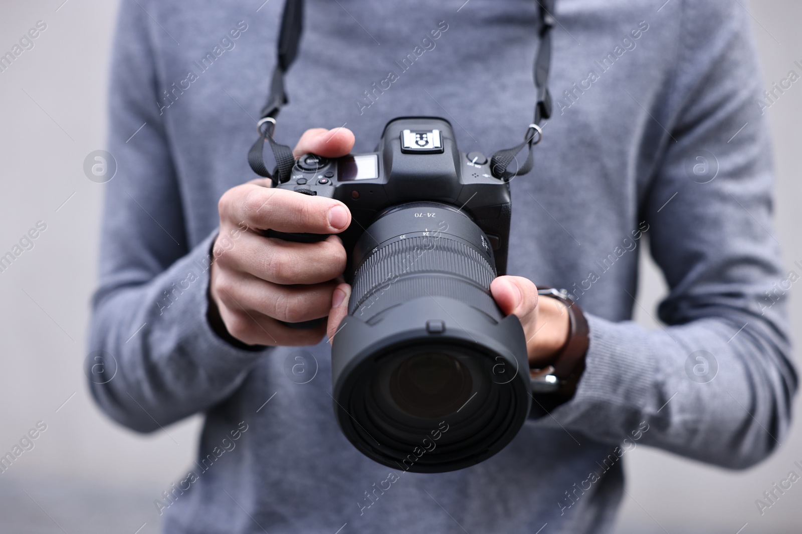 Photo of Professional photographer with modern camera outdoors, closeup