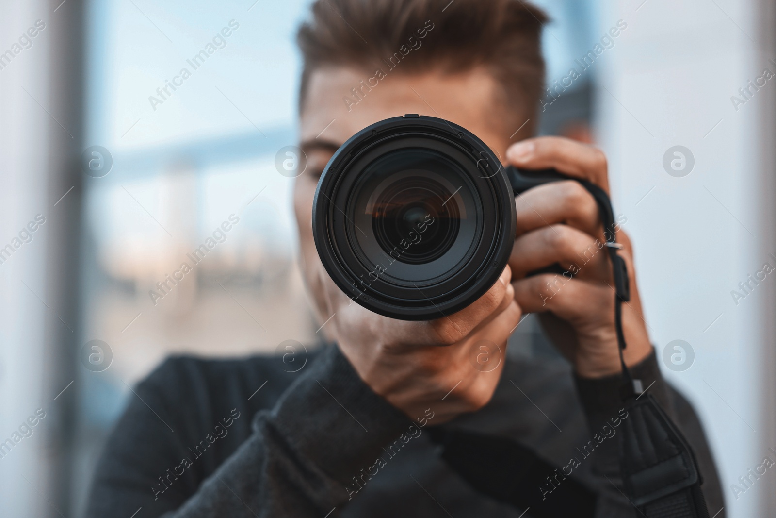 Photo of Professional photographer taking picture with camera outdoors, selective focus