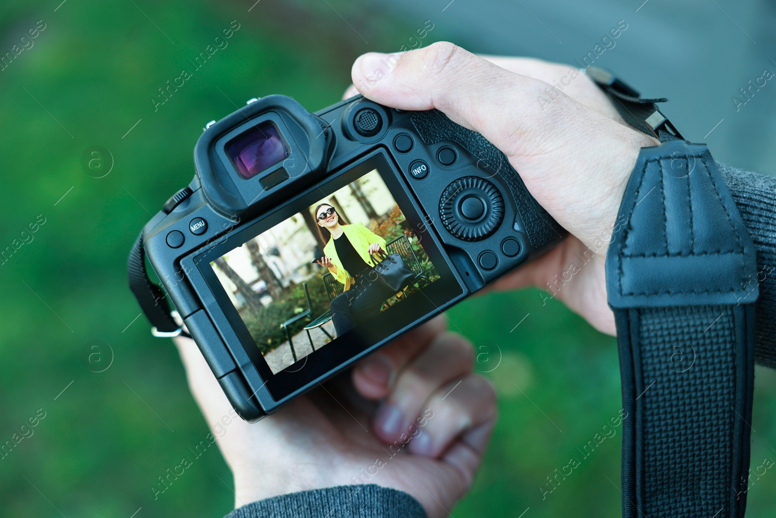 Photo of Professional photographer with modern camera outdoors, closeup