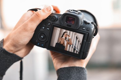 Photo of Professional photographer with modern camera outdoors, closeup