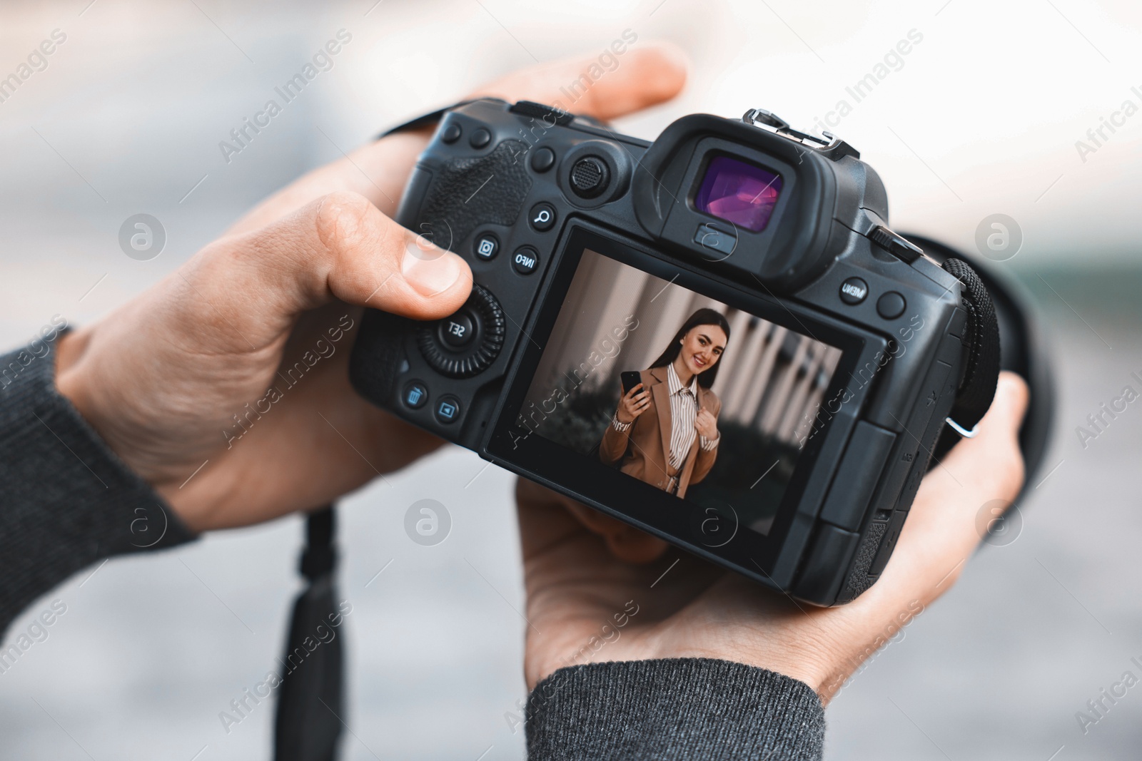 Photo of Professional photographer with modern camera outdoors, closeup