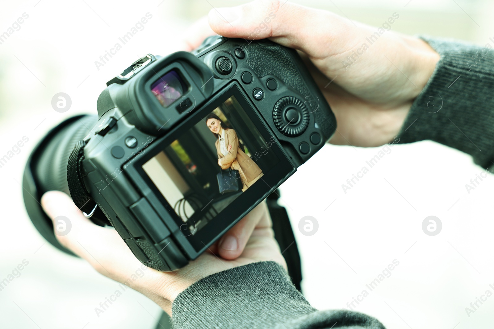 Photo of Professional photographer with modern camera outdoors, closeup