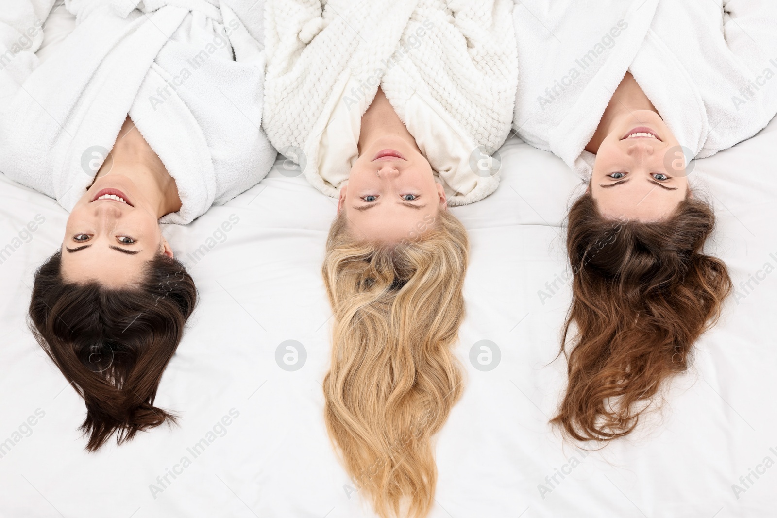 Photo of Spa day. Happy women lying on bed, above view