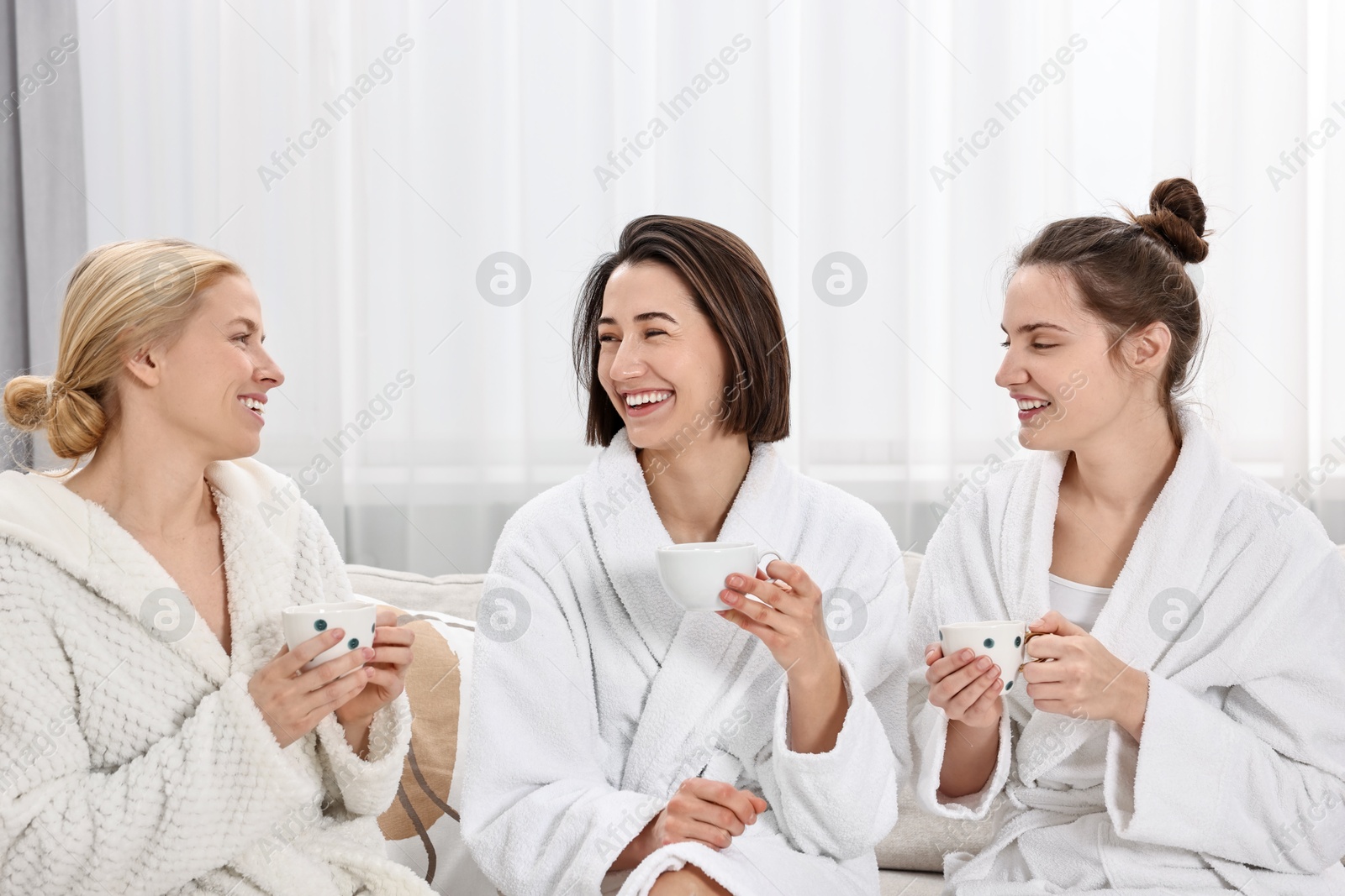 Photo of Beautiful women having tea on sofa in spa