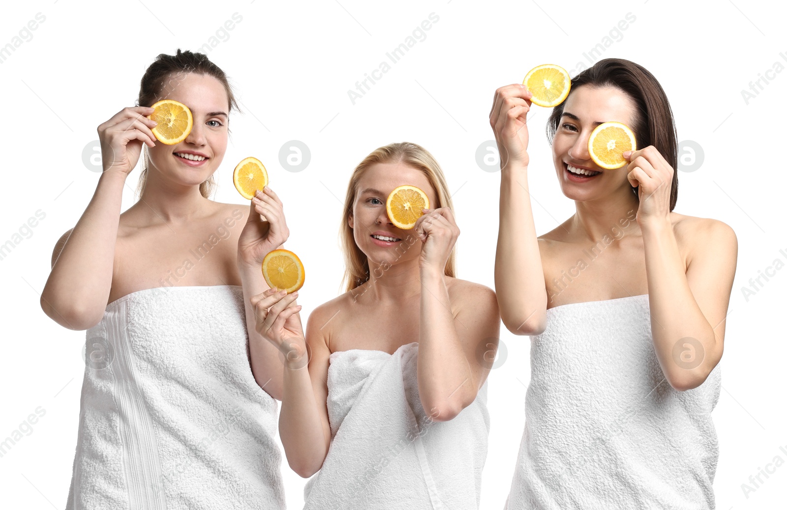 Photo of Spa day. Cheerful women wrapped in towels with orange slices on white background