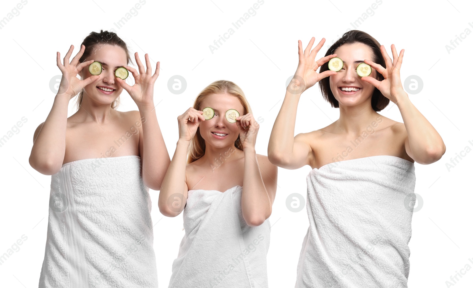 Photo of Spa day. Cheerful women wrapped in towels with cucumber slices on white background