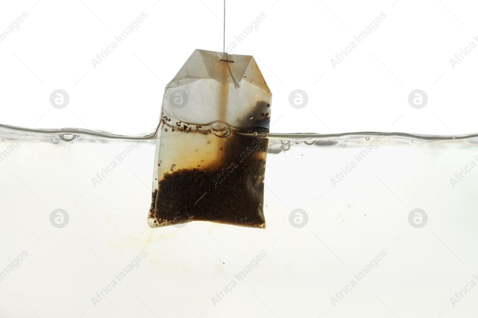 Photo of Putting tea bag into glass cup on white background, closeup