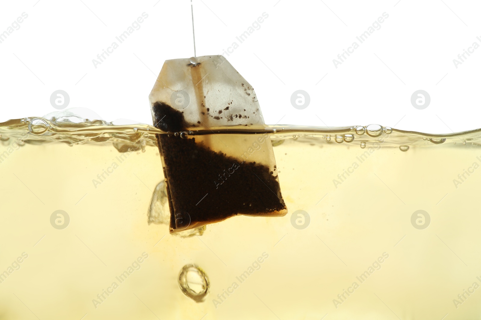 Photo of Putting tea bag into glass cup on white background, closeup