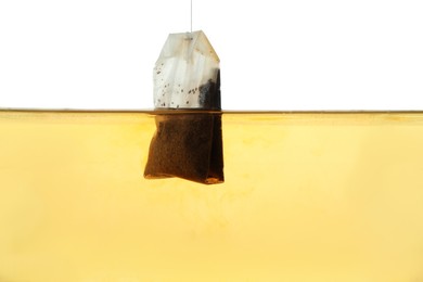 Photo of Putting tea bag into glass cup on white background, closeup