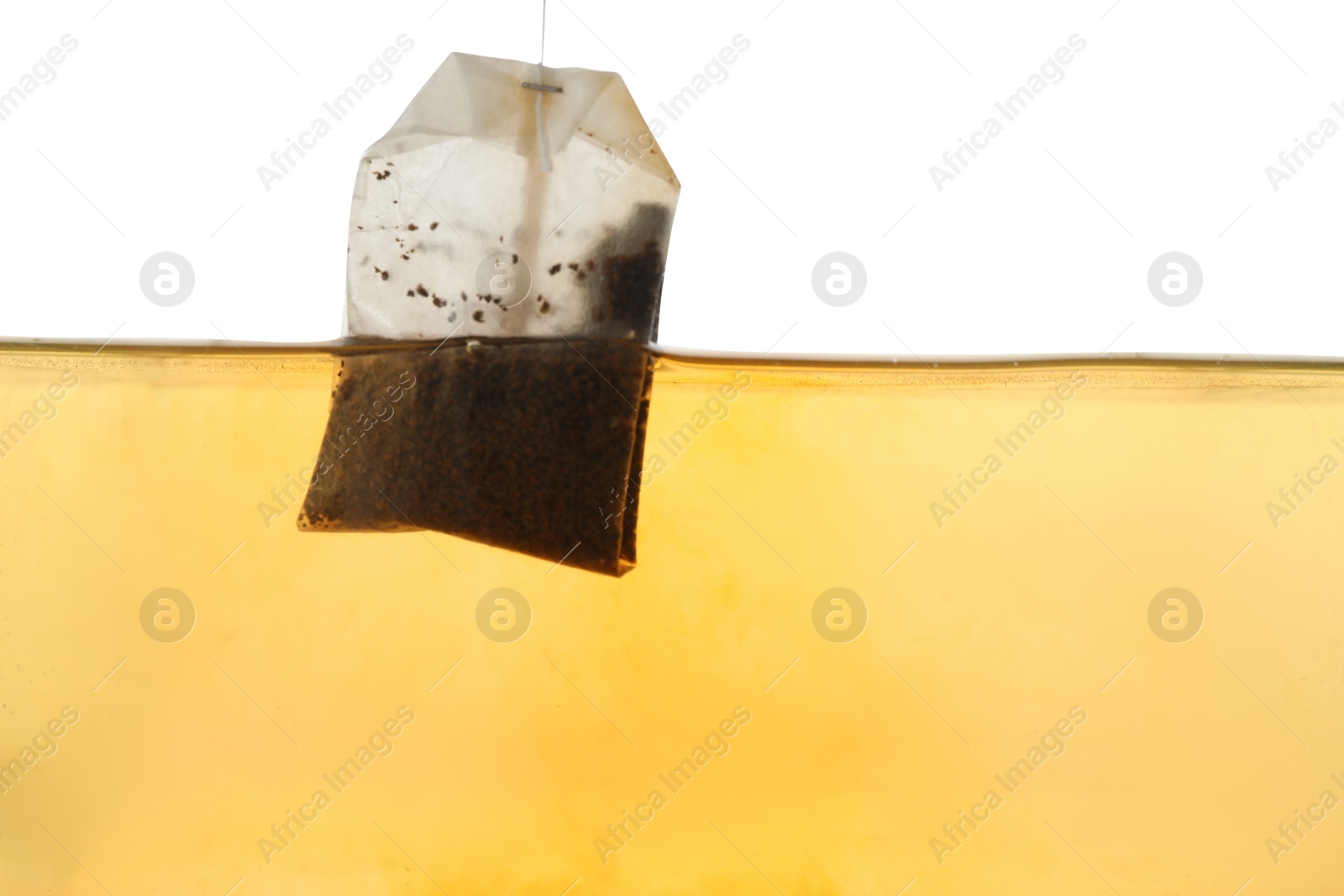 Photo of Putting tea bag into glass cup on white background, closeup