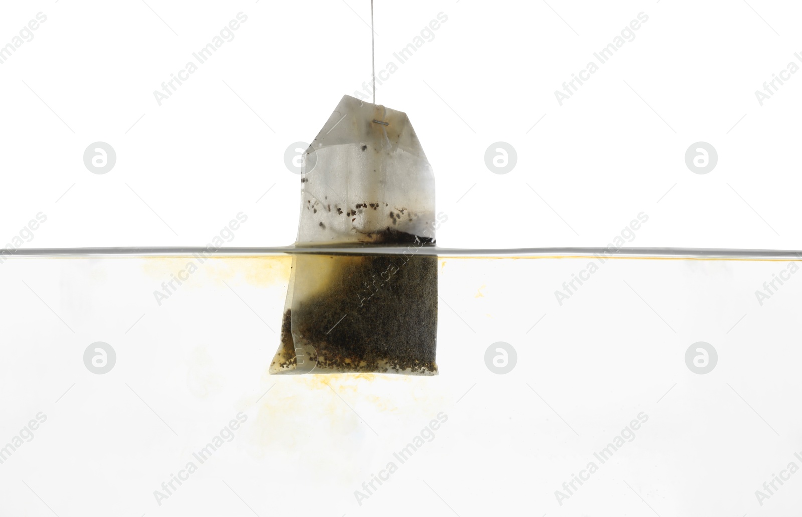 Photo of Putting tea bag into glass cup on white background, closeup