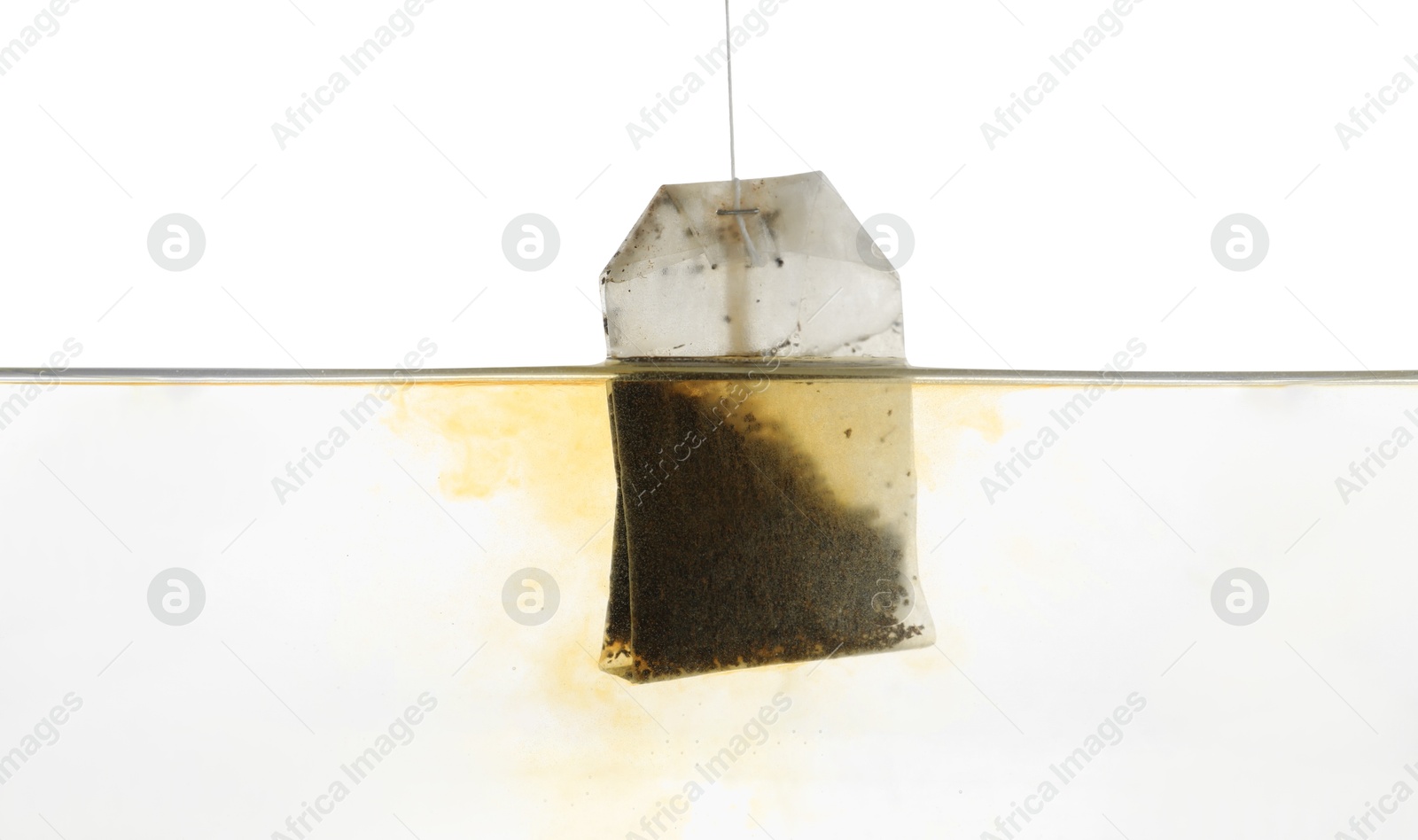 Photo of Putting tea bag into glass cup on white background, closeup