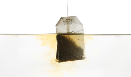 Photo of Putting tea bag into glass cup on white background, closeup