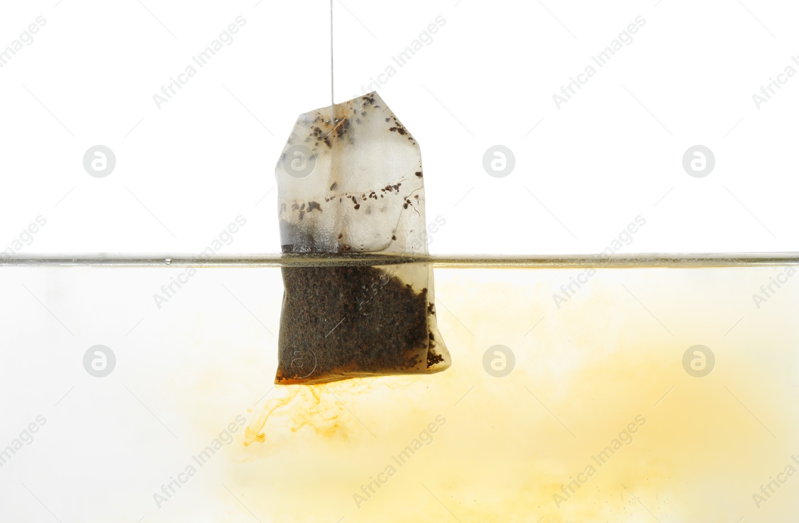 Photo of Putting tea bag into glass cup on white background, closeup